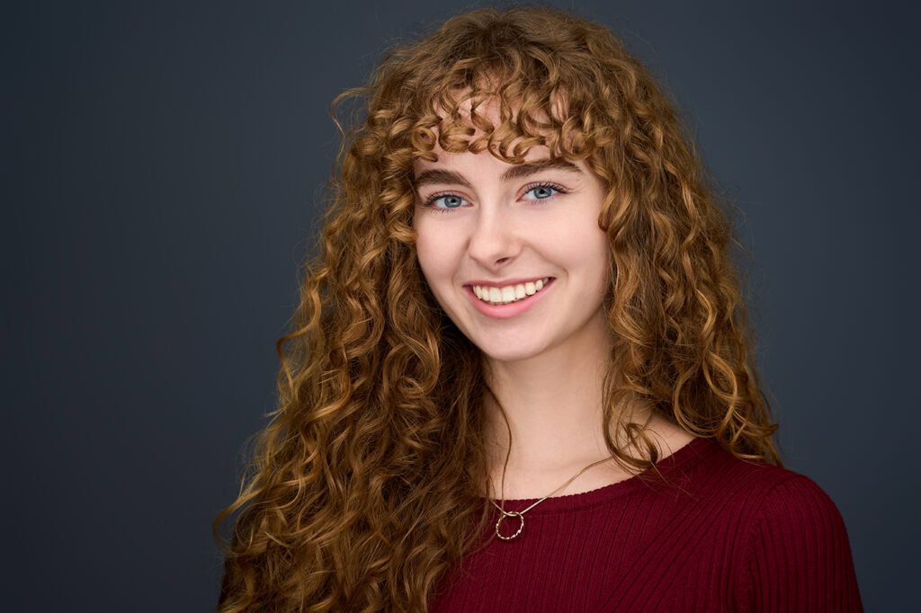 Portrait de femme souriante en studio, photographie corporate professionnelle.